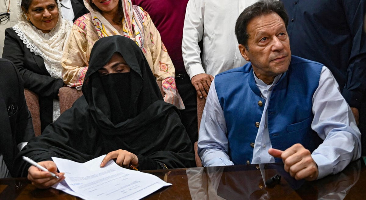 PTI founder-chairman Imran Khan and his wife Bushra Bibi are pictured while signing surety bonds for bail in various cases, at a registrar office in the Lahore High Court on July 17, 2023. — AFP