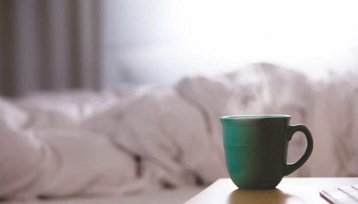 A representational image depicting a hot beverage cup kept at a table in a persons room. — Unsplash/File