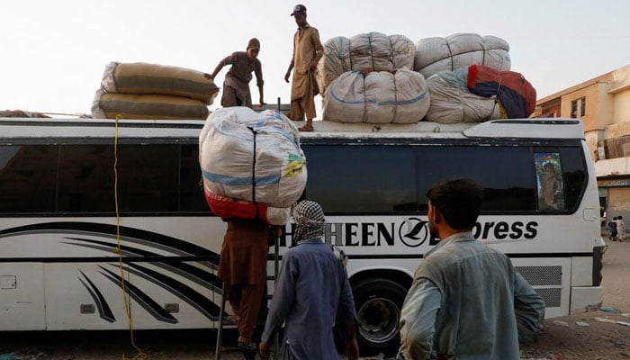 A representational image depicting Afghan men loading their belongings on a bus. — Reuters/File