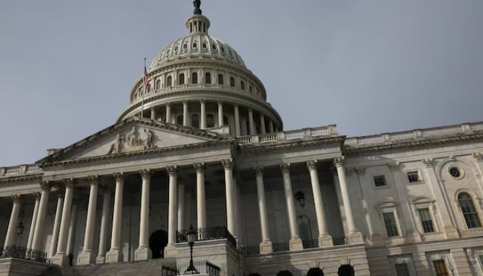 People walk past the US Capitol building as the deadline to avoid partial government shutdown looms in Washington, US, on January 18, 2024. —Reuters