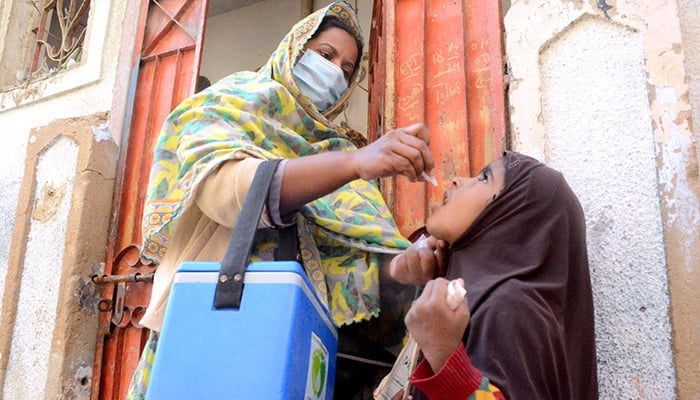 A lady health worker administering polio drops to a child during anti-polio campaign in Karachi, on December 18, 2024. — APP