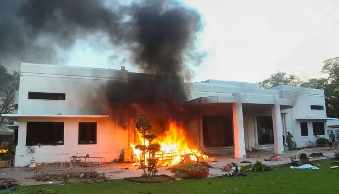 Fire burns at Lahores Jinnah House after being attacked by PTI supporters on May 9, 2023. — Reuters