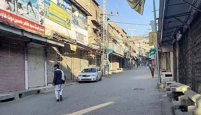 Men walk past a market closed by traders during a strike in Kurram district, Parachinar, the mountainous Khyber Pakhtunkhwa province, on November 22, 2024. — AFP