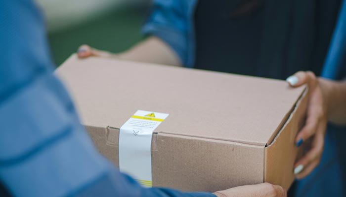 A representational image of a delivery man giving a package. — Unsplash