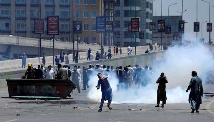 Supporters of Pakistan Tehreek-e-Insaf (PTI) throw stones at police during a protest against Imran Khans arrest, in Peshawar, May 10, 2023. — Reuters