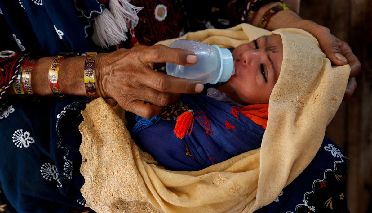 A mother gives water to her six-day-old baby, Darya Khan, to cool off during a hot summer day as the heatwave continued in Jacobabad, May 25, 2024. — Reuters