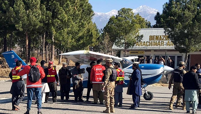 Volunteers of Edhi with security personnel surround a plane carrying medicines for victims injured in clashes, upon its arrival in Parachinar, at Kurram district, on December 17, 2024. — AFP