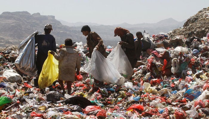 People collect recyclable items from piles of garbage. — Reuters/File