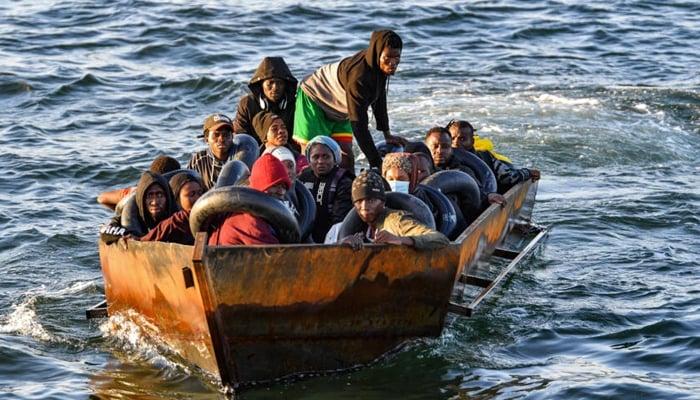 Migrants from sub-Saharan Africa sit in a makeshift boat off the coast of Tunisias city of Sfax on October 4, 2022. — AFP