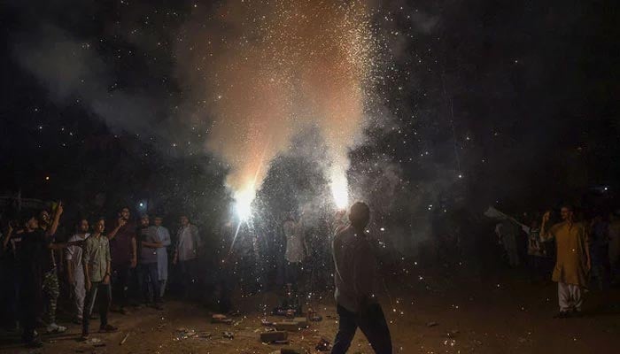 Youths hold lit fireworks during celebrations for Pakistans 75th anniversary of Independence Day in Karachi on August 14, 2022. — AFP