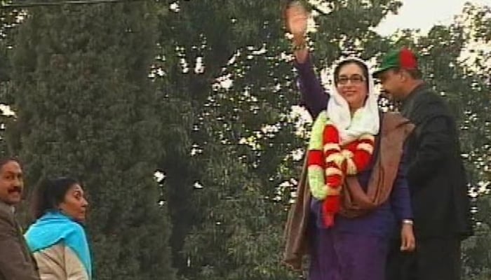 Former prime minister Benazir Bhutto waves as she leaves a rally in the city of Rawalpindi shortly before she was killed in a gun and bomb attack, December 27, 2007. — Reuters