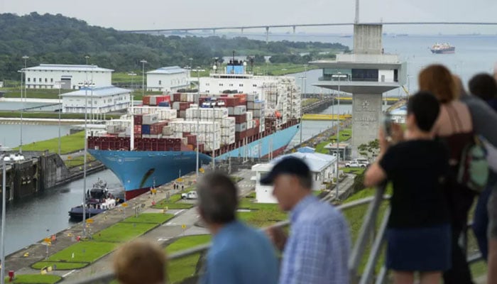 Tourists watch a Danish-flagged cargo ship passing through the Panama Canal. — AFP/File