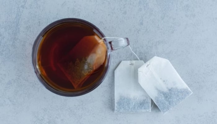 The image shows three tea bags including one dipped in water. — APP/ File