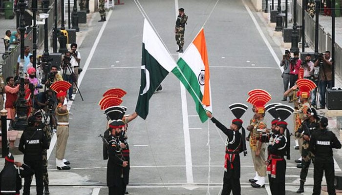 Pakistani Rangers (wearing black uniforms) and Indian Border Security Force (BSF) officers lower their national flags during parade on the Pakistans 72nd Independence Day, at the Pakistan-India joint check-post at Wagah border on August 14, 2019. — Reuters