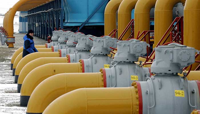 A gas worker walks between pipes in a compressor and distribution station of the Urengoy-Pomary-Uzhgorod gas pipeline, some 30km from south western Russian city of Kursk January 4, 2006. — Reuters