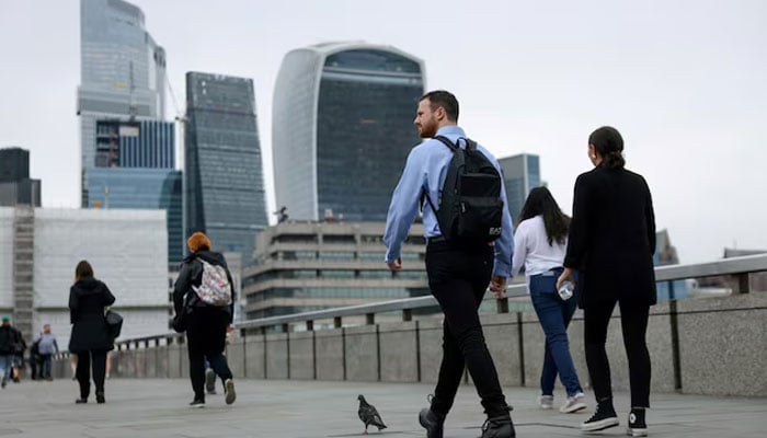 A representational image shows commuters cross London Bridge in view of the City of London skyline in London, Britain, July 25, 2024. — Reuters