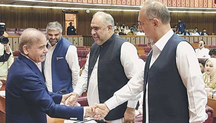 The representational image shows PM Shehbaz Sharif (left) greeting PTI leaders Omar Ayub and Asad Qaiser during National Assembly proceedings.— Facebook@National Assembly of Pakistan/File