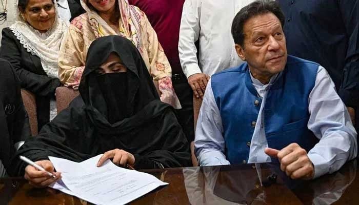 Former prime minister Imran Khan along with his wife Bushra Bibi as she signs surety bonds for bail in various cases, at the registrars office in the Lahore High Court on July 17, 2023. — AFP