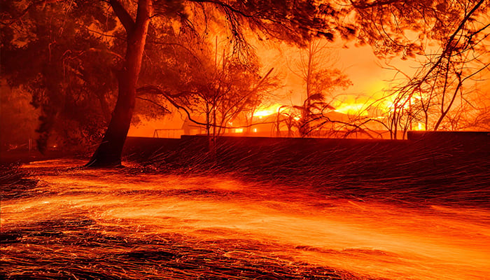 Embers whip across the ground as homes burn during the Eaton fire in Pasadena, California on January 7, 2025. — AFP