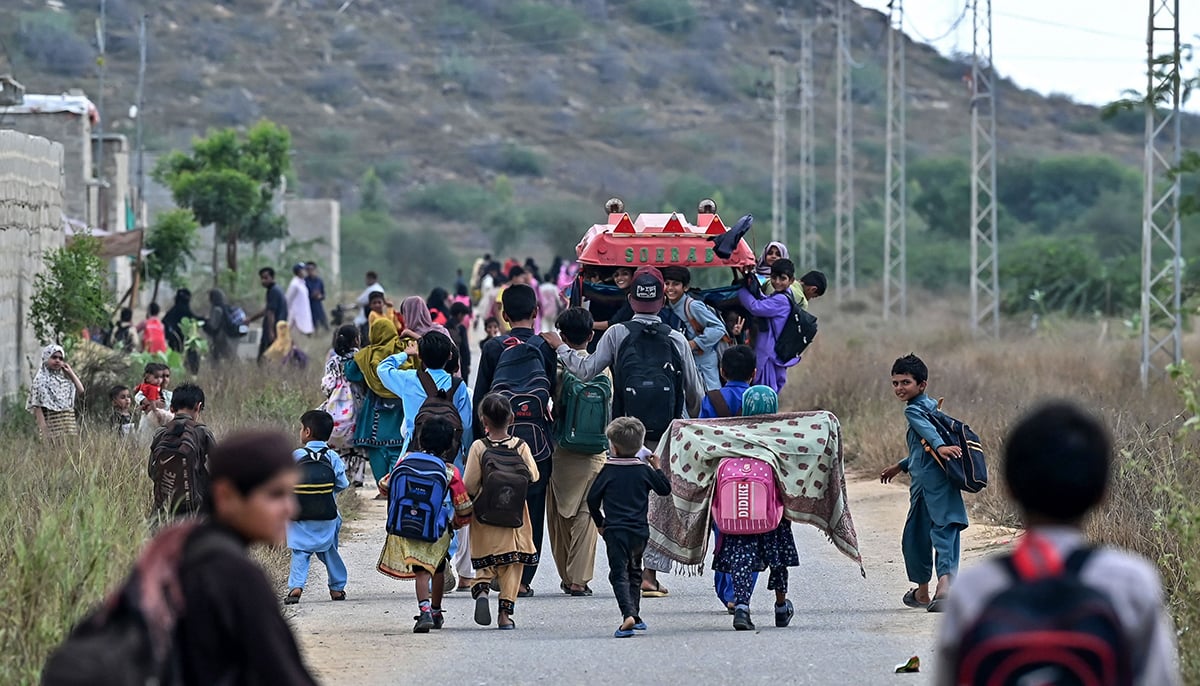 This photo taken on November 13, 2024 shows students going back to their home from a community school in Abdullah Goth village on the outskirts of Karachi. — AFP