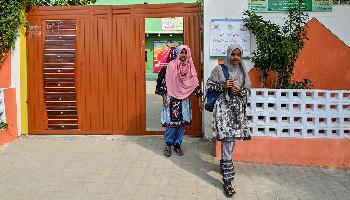 This photo taken on November 13, 2024 shows Aneesa Haroon (left) and Zulekha Mahmood leaving a community school in Abdullah Goth village on the outskirts of Karachi. — AFP