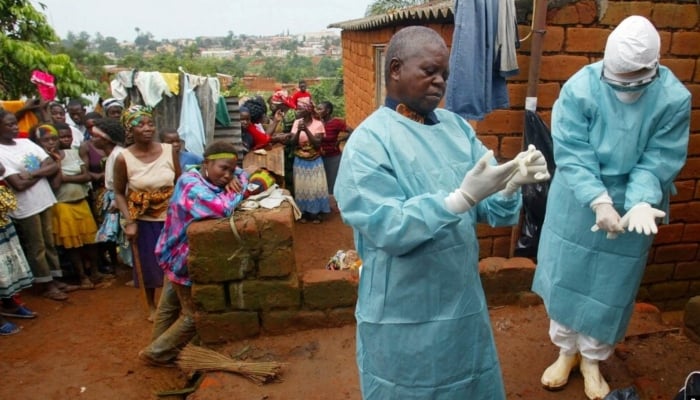 World Health Organisation officials examine the home of a suspected Marburg virus victim in Uige, Angola, on April 19, 2005. — Reuters