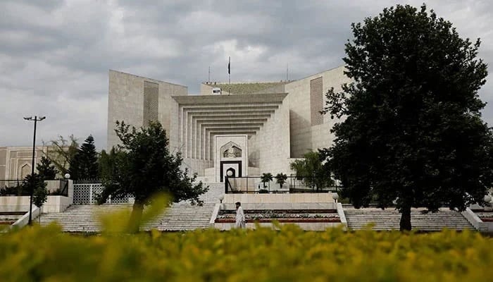 A man uses his mobile phone as he walks past the Supreme Court building in Islamabad on May 13, 2023. — AFP