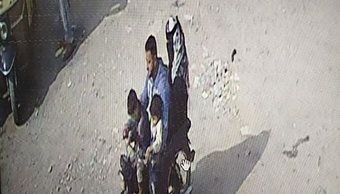 A screengrab from a CCTV footage showing alleged kidnappers on a motorcycle with children reportedly abducted from Karachis Garden area. — Reporter