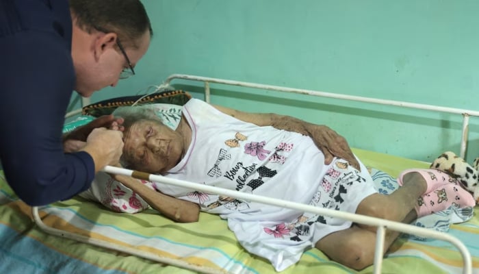 Geriatric doctor Juair de Abreu Pereira talks with his patient Deolira Gliceria Pedro da Silva, 119, in her house in Itaperuna, Rio de Janeiro state, Brazil, on January 14, 2025. — Reuters