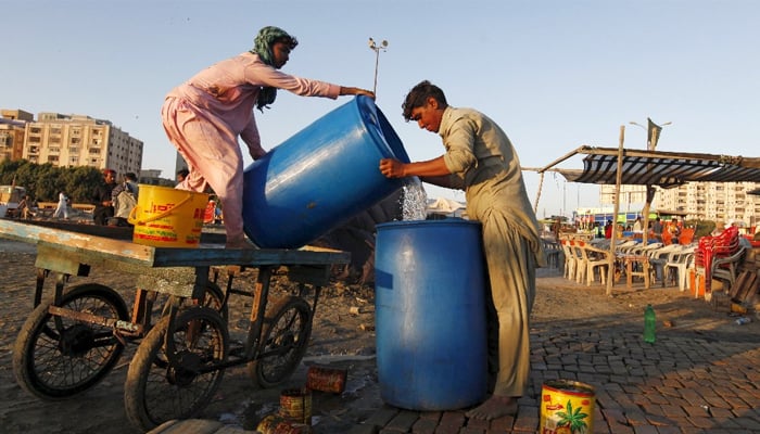 Two youngsters transfer water from a PVC tank to another in this undated image. — Reuters/File