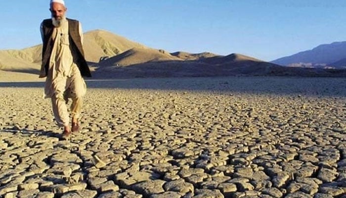 A man walks on the dried, cracked landscape near Hanna Lake neat Quetta. — AFP/File