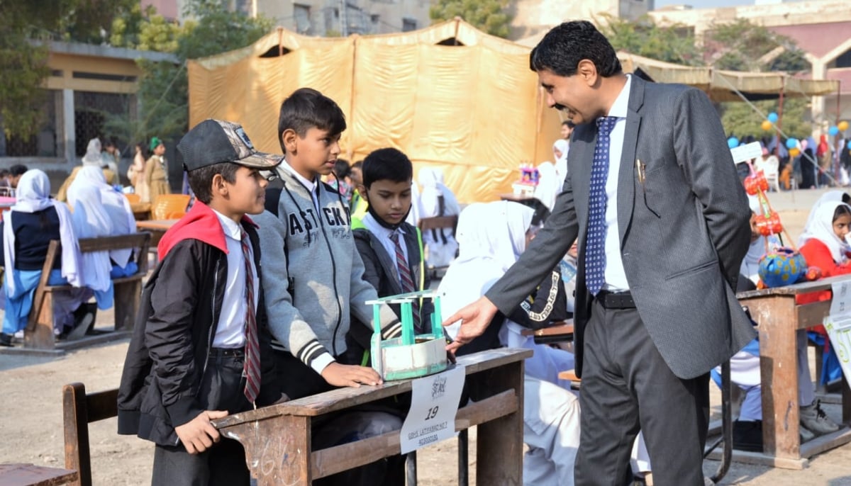 District Education Officer Hyderabad Aziz Rehman Dahot interacts with Hyder, Ahsan, and Irfan from GBHS Latifabad no 7 after they presented their project in the Float Your Boat category for the Hyderabad STEAM Muqablo, that happened on January 11, 2025. — Photo via author