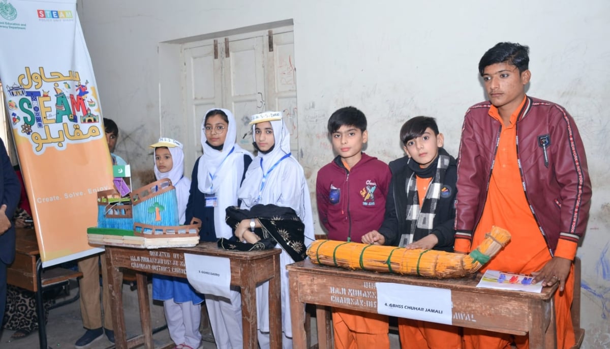 Gulzar (right) Shoban and Adeeb from Chuhar Jamali wait to present their boat made from panno, with other participating teams at the Sujawal STEAM Muqablo. — Photo via author