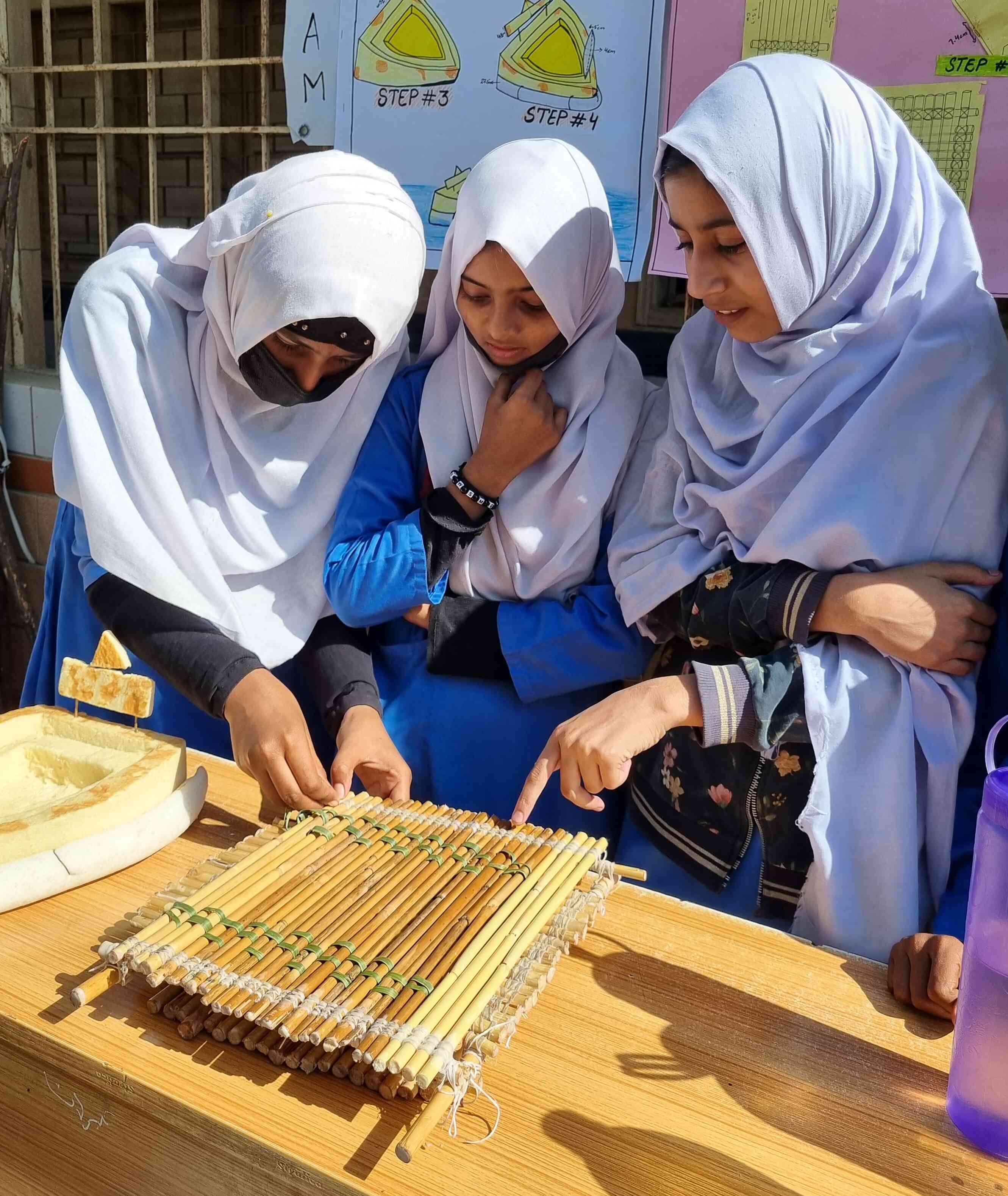 Dua (left), Maryam and Haniya from Gharibabad Malir present their eco-friendly raft. — Photo via author