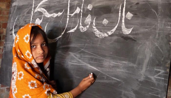 A student writes on blackboard in at a non-formal school in Punjab. — Literacy.punjab.gov.pk