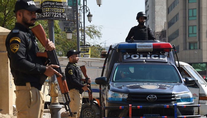 This representational image shows policemen stand guard during general elections in Karachi on February 8, 2024. — AFP