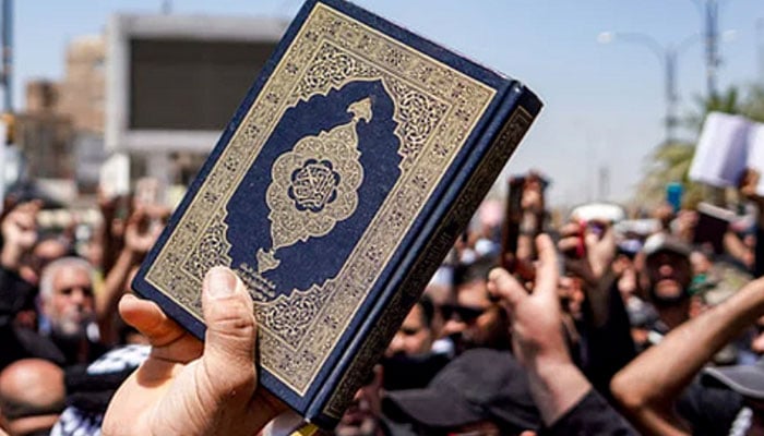 This undated photo shows a person hold a copy of the Holy Quran in his and during a protest demonstration against the desecration of the holy book. — AFP/File