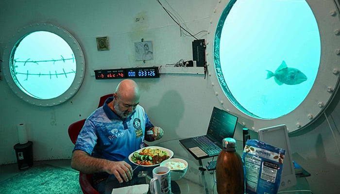 German aerospace engineer Rudiger Koch, 59, takes breakfast inside an underwater room off the coast of Puerto Lindo, Panama, on January 24, 2025. — AFP