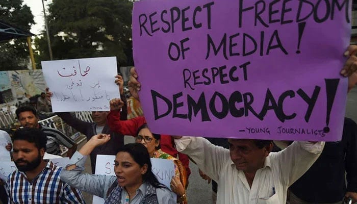 Journalists and civil society activists hold placards against the attack on a senior journalist of a local newspaper in Karachi on October 28, 2017. — AFP