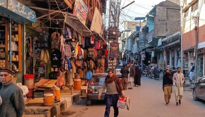 This photograph taken on December 3, 2024, shows local residents walking across a market reopened after  clashes in Parachinar, Khyber Pakhtunkhwa. — AFP