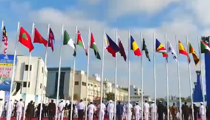 Representatives from different regional navies stand under flags of their respective countries during an event under AMAN exercise in this still taken from a video. — X/@dgprPaknavy