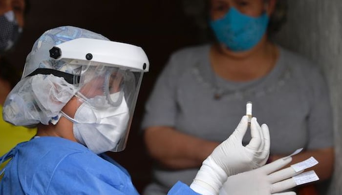 A health worker performs a COVID-19 test in the Kennedy neighborhood of Bogota, Colombia. — AFP/File