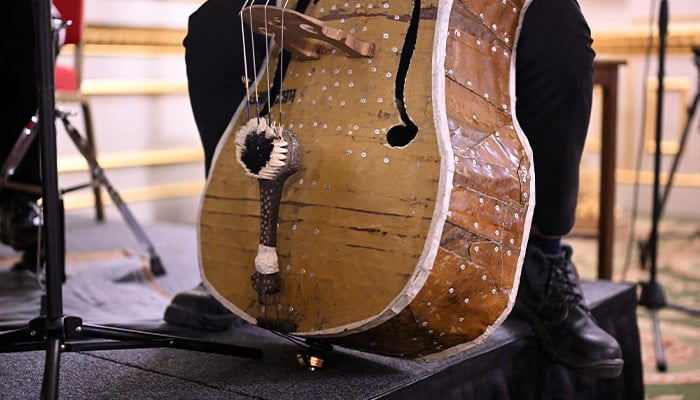 A brush is seen in a double base as members of the Paraguayan Recycled Orchestra of Cateura perform for an audience inside Lancaster House in London on January 26, 2025. — AFP