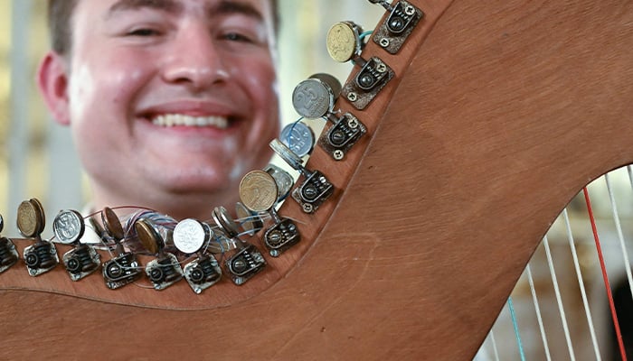 A harpist with the Paraguayan Recycled Orchestra of Cateura poses with his instrument, partly made with 25c coins, ahead of a performance for an audience inside Lancaster House in London on January 26, 2025. — AFP