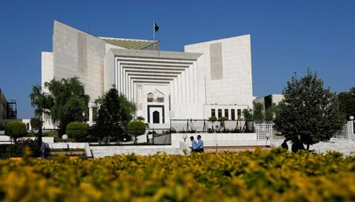 Police officers walk past the Supreme Court in Islamabad on April 6, 2022. — Reuters