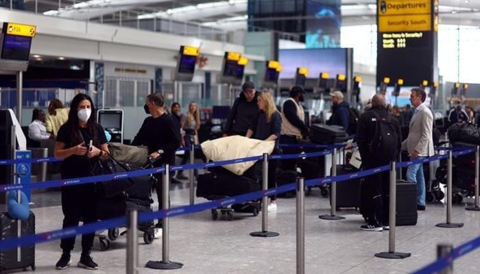 Passengers queue for the check in desk at Heathrow Terminal 5 airport in London, Britain, June 1, 2022.— Reuters