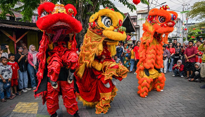 Lion dancers perform for the crowd on the first day of the Lunar New Year of the Snake at Chinatown in Surabaya on January 29, 2025. — AFP