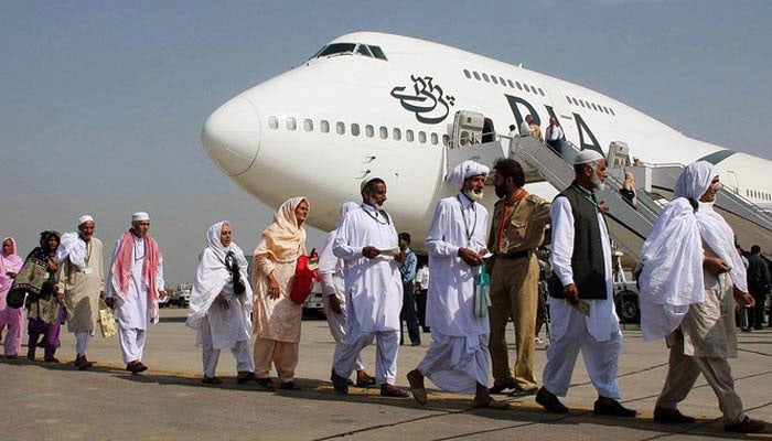 Pakistani pilgrims walk in line as they prepare to board a PIA flight. — AFP/File