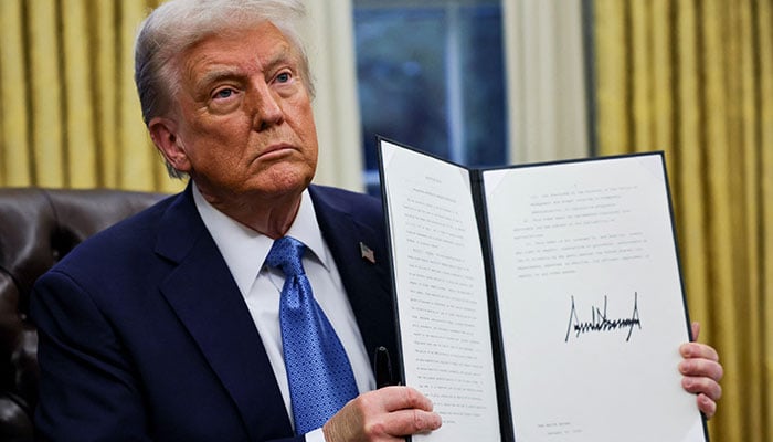 US President Donald Trump holds a signed executive order in the Oval Office at the White House in Washington, US, January 31, 2025. — Reuters