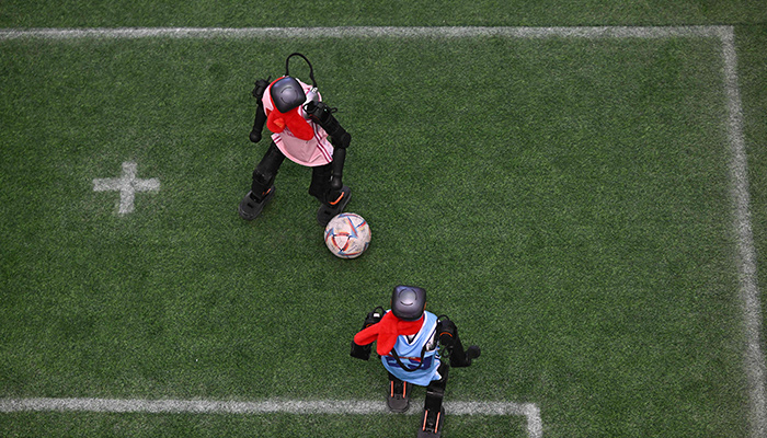 Robots vie for the ball during an exhibition football match at the Spring Festival Science and Technology Temple Fair in Beijing on January 31, 2025. — AFP